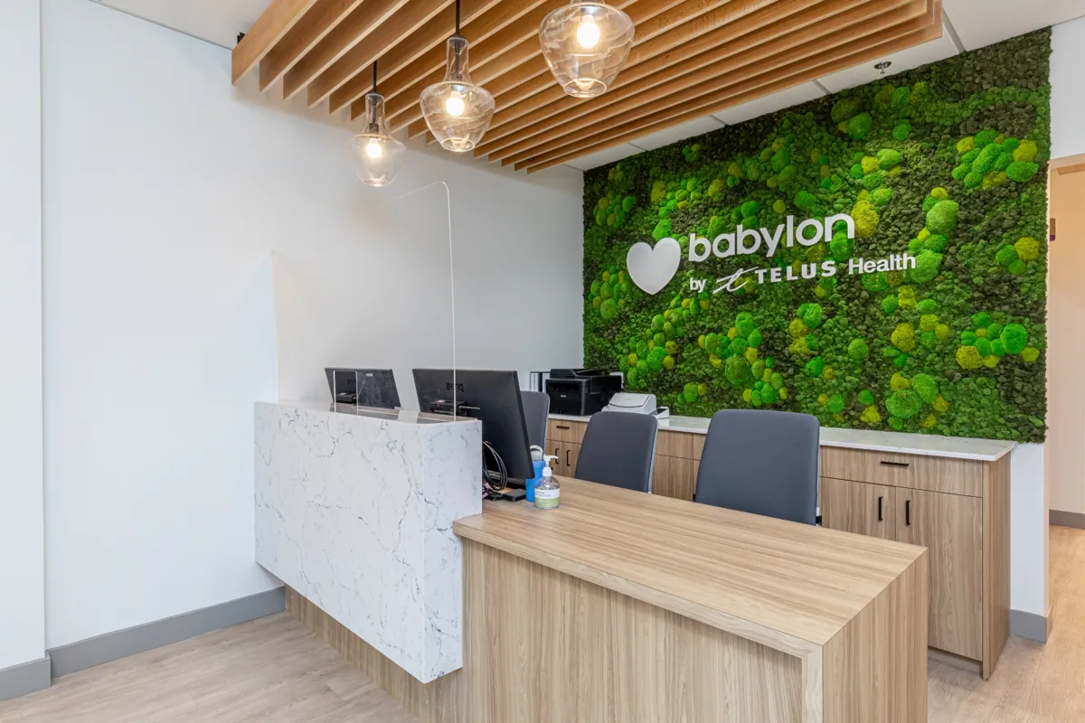 Reception with a living moss wall at Babylon by TELUS Health, Victoria